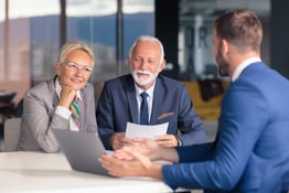 Positive aged couple consulting with agent