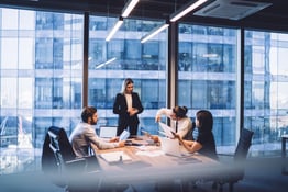 Serious female entrepreneur checking wristwatch during meeting in office