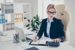 Woman sitting behind desk doing accounting