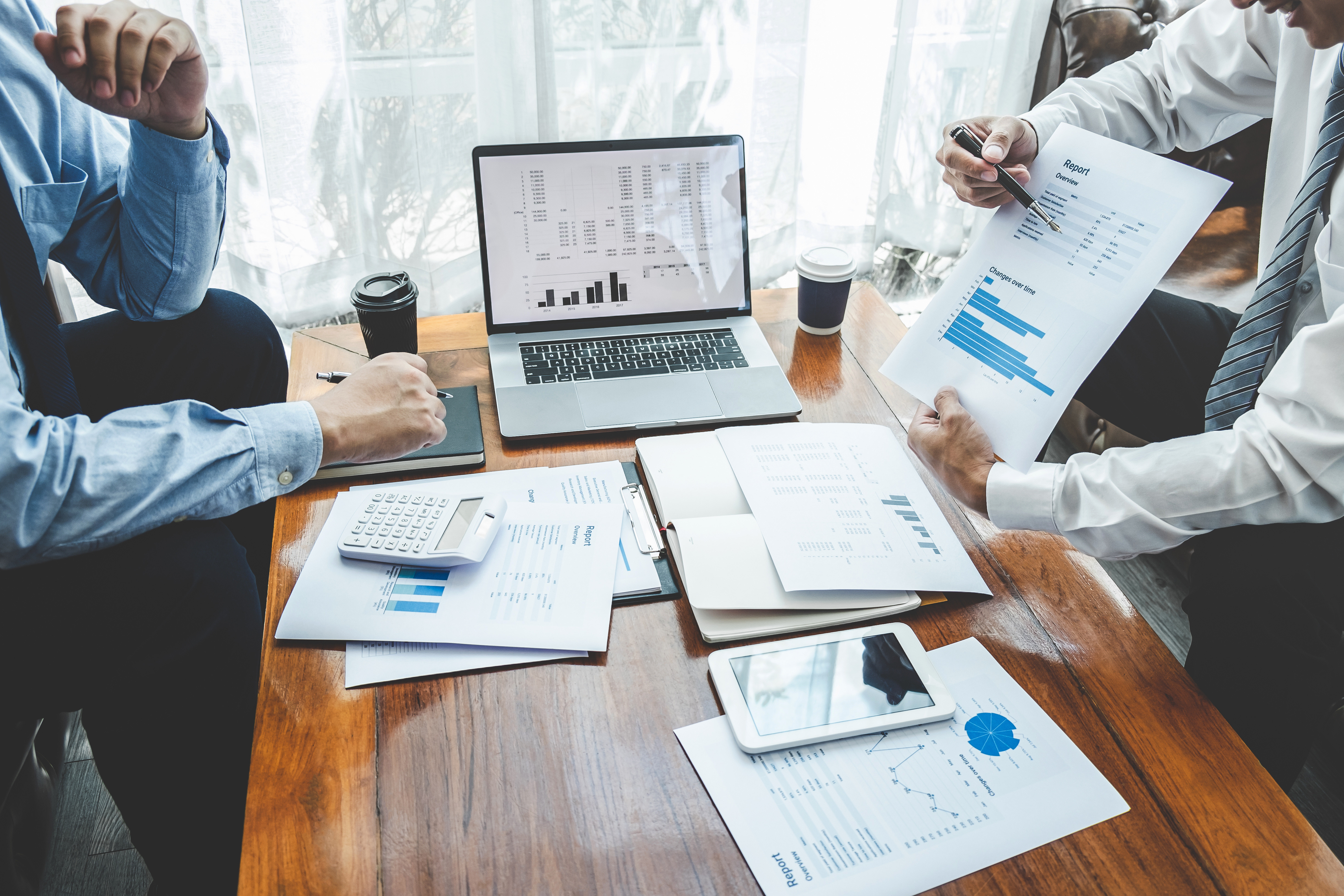 Two businessmen looking at accounting data charts and analyzing data