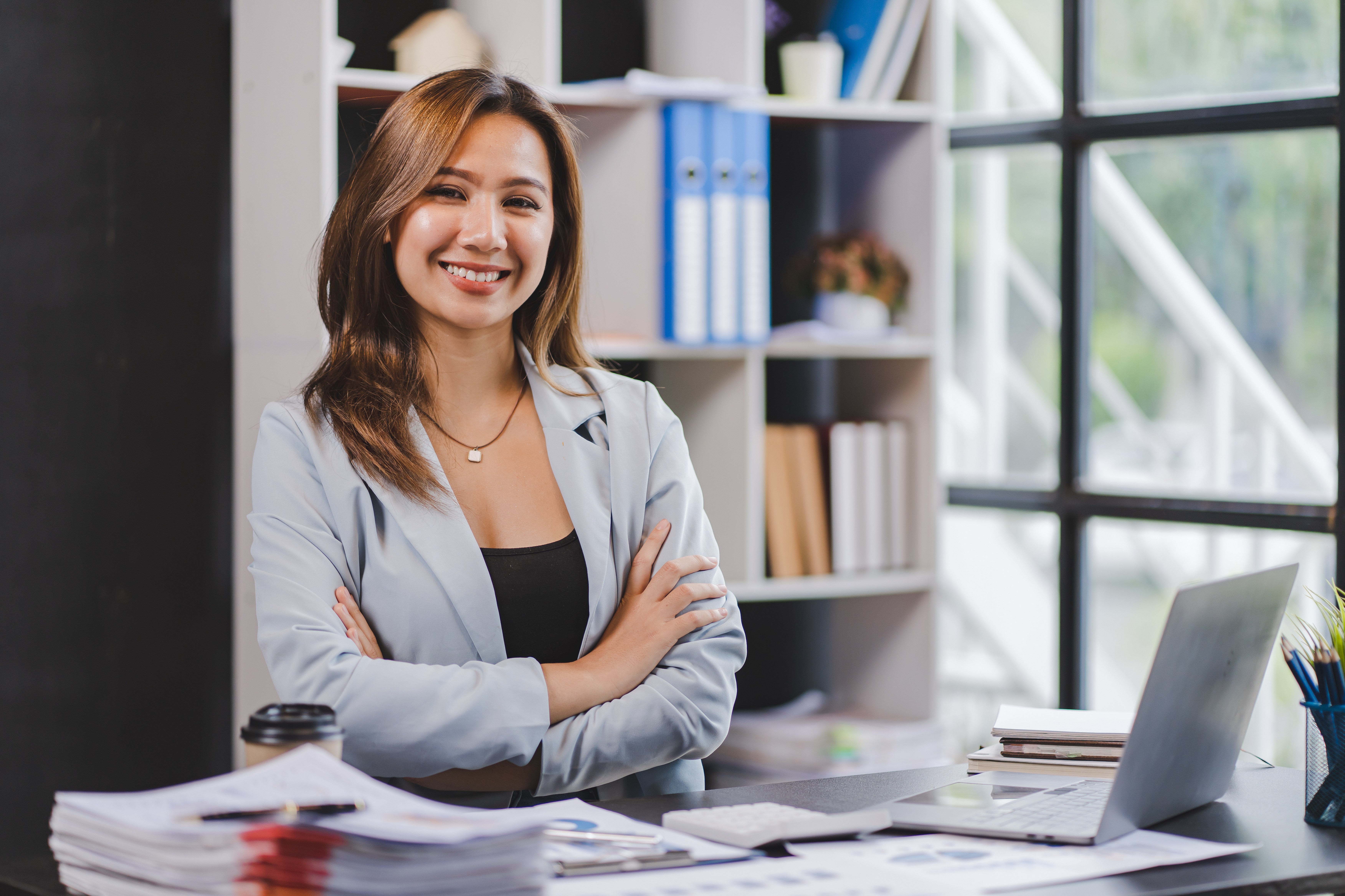 Smiling Asian businesswoman working on laptop in modern office Accountant Concept Finance Expert Analyze Business Report Graph financial chart financial chart corporate economy Banking Market Research